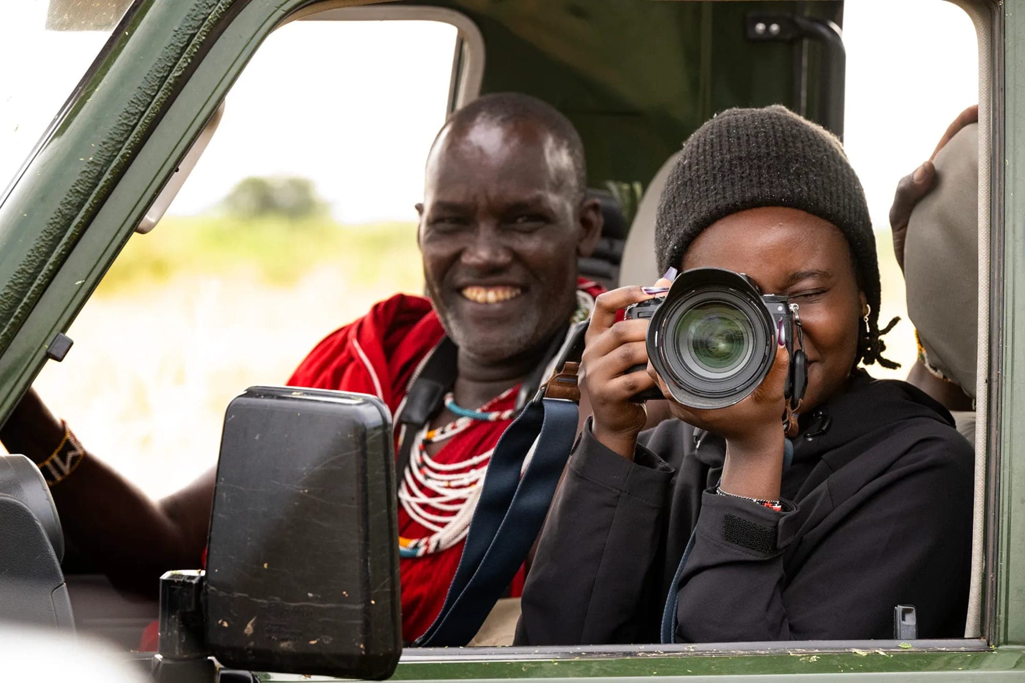 Gacheri crouching low to photograph a pride of lions at sunrise in the Masai Mara